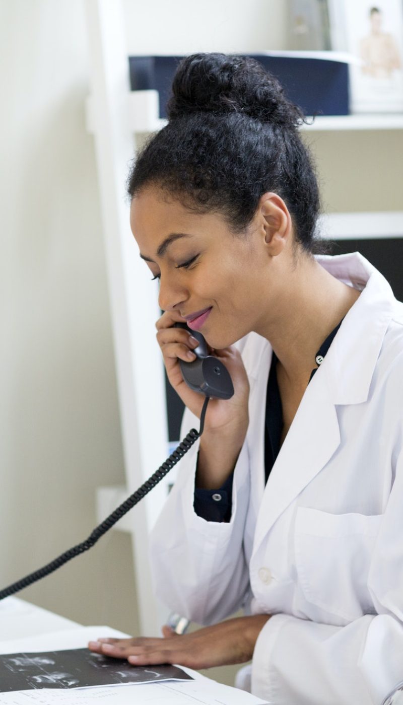 Doctor at desk making telephone call